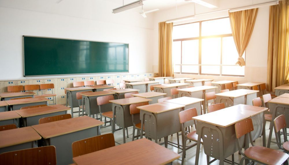 An Empty Classroom With Tables and Chairs and a Blackboard — Bellarine Removals In Geelong, VIC