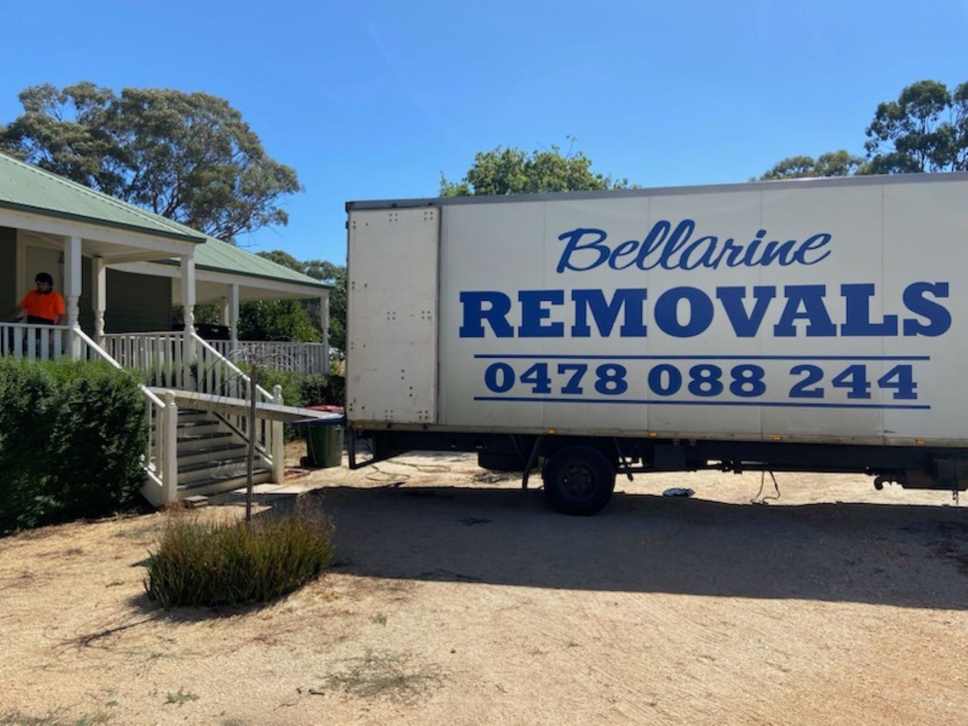 Two Men Are Carrying a Large Piece of Furniture Out of a Moving Truck — Bellarine Removals In Geelong, VIC