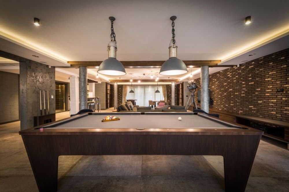 A Pool Table in a Living Room With Two Lamps Hanging From the Ceiling — Bellarine Removals In Melton, VIC