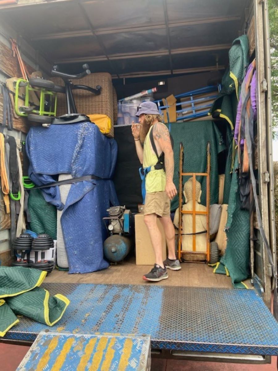 A Man is Standing in the Back of a Truck — Bellarine Removals In Warrnambool, VIC