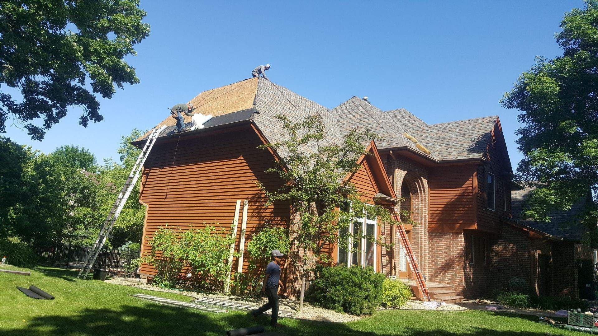 Rustic wooden cottage with ivy-covered walls and a shingled roof in a sunny green garden