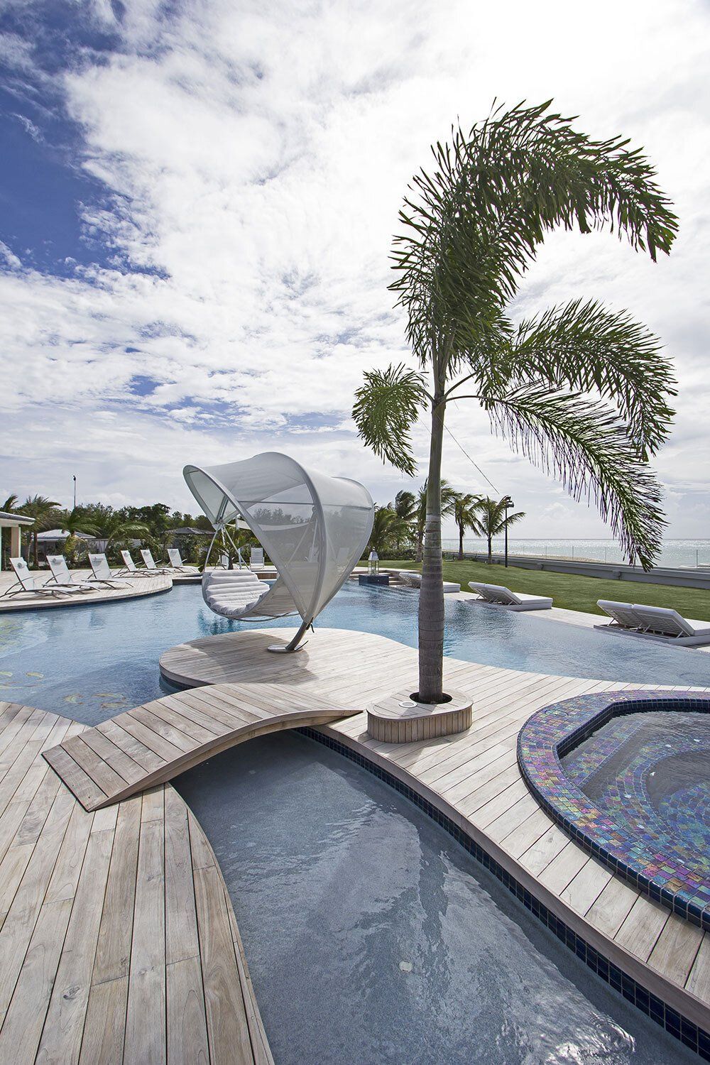 A large swimming pool with a palm tree in the middle