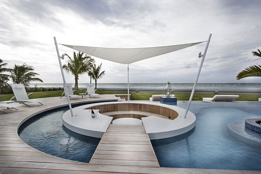 A large swimming pool with a white umbrella over it