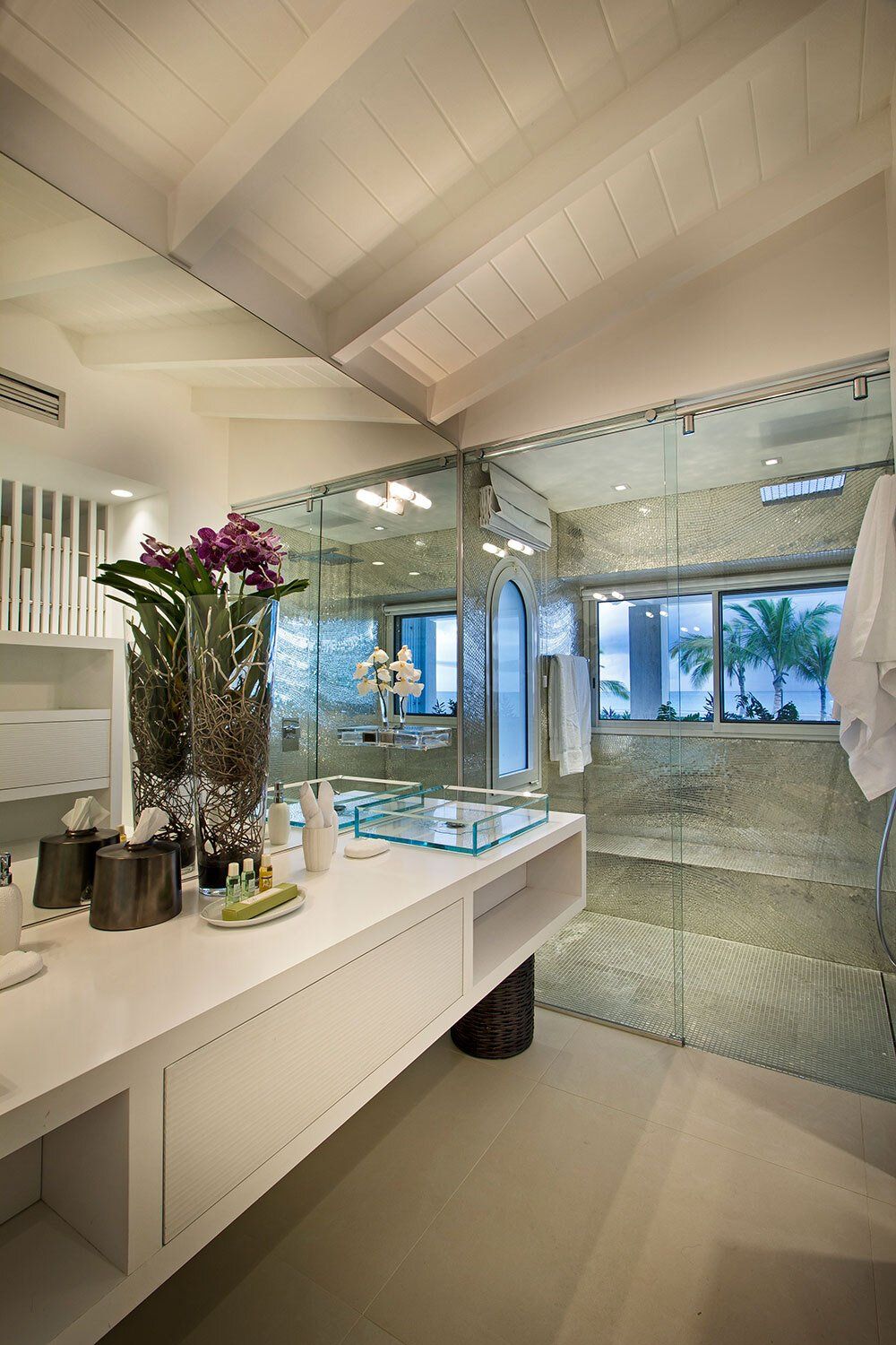 A bathroom with a sink , mirror , and walk in shower.