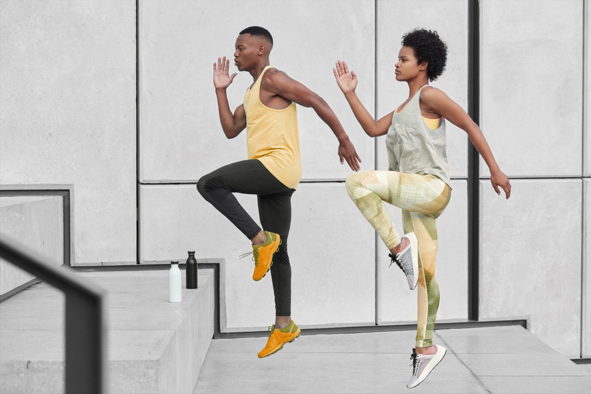 A man and a woman are doing exercises on a set of stairs.