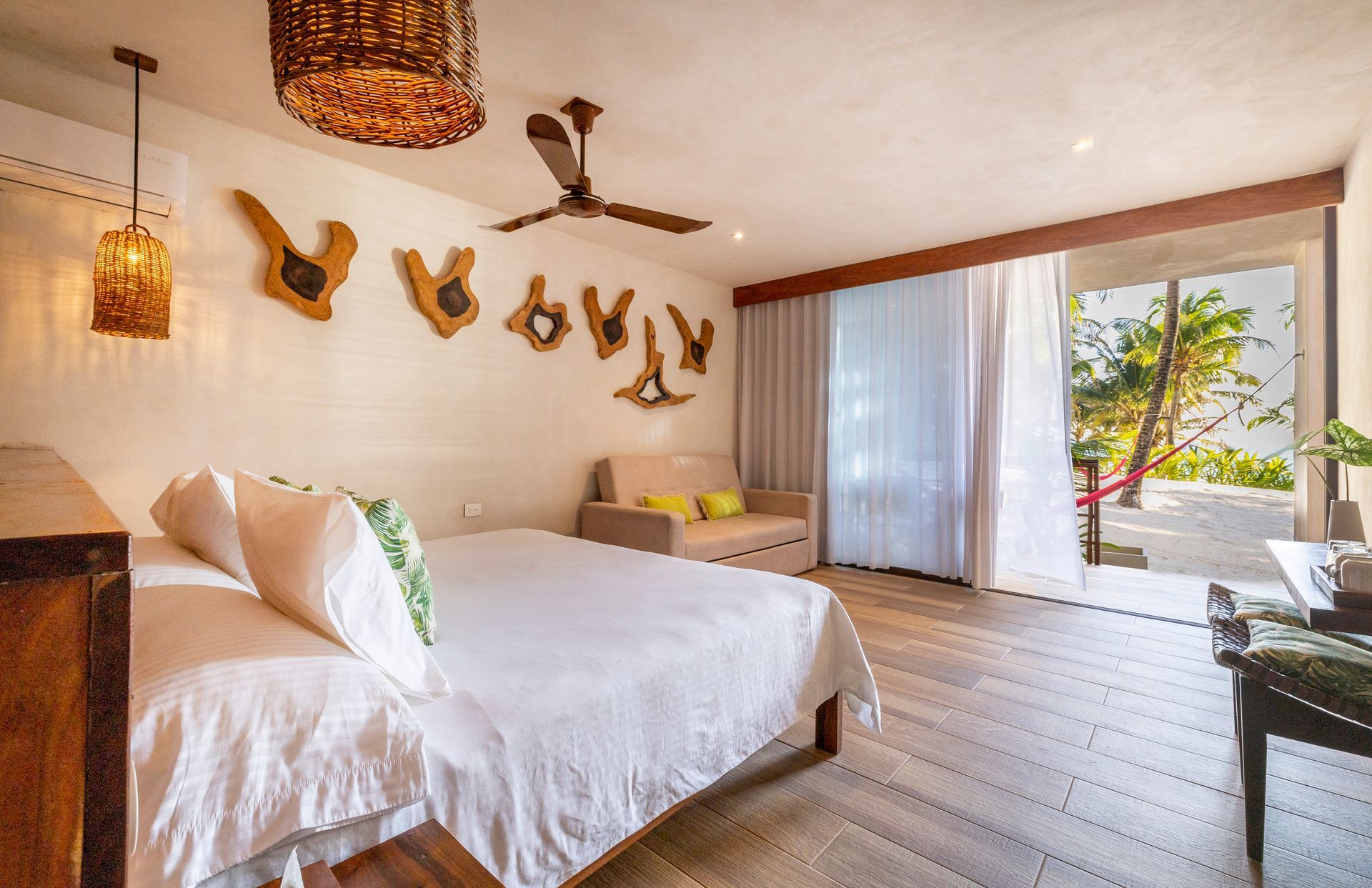 Bedroom with white bedding, wooden accents, and a view of a beach.