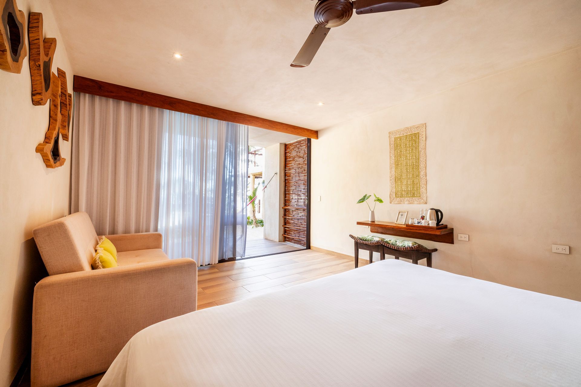 Bedroom with a bed, sofa, and a door leading to the outside.