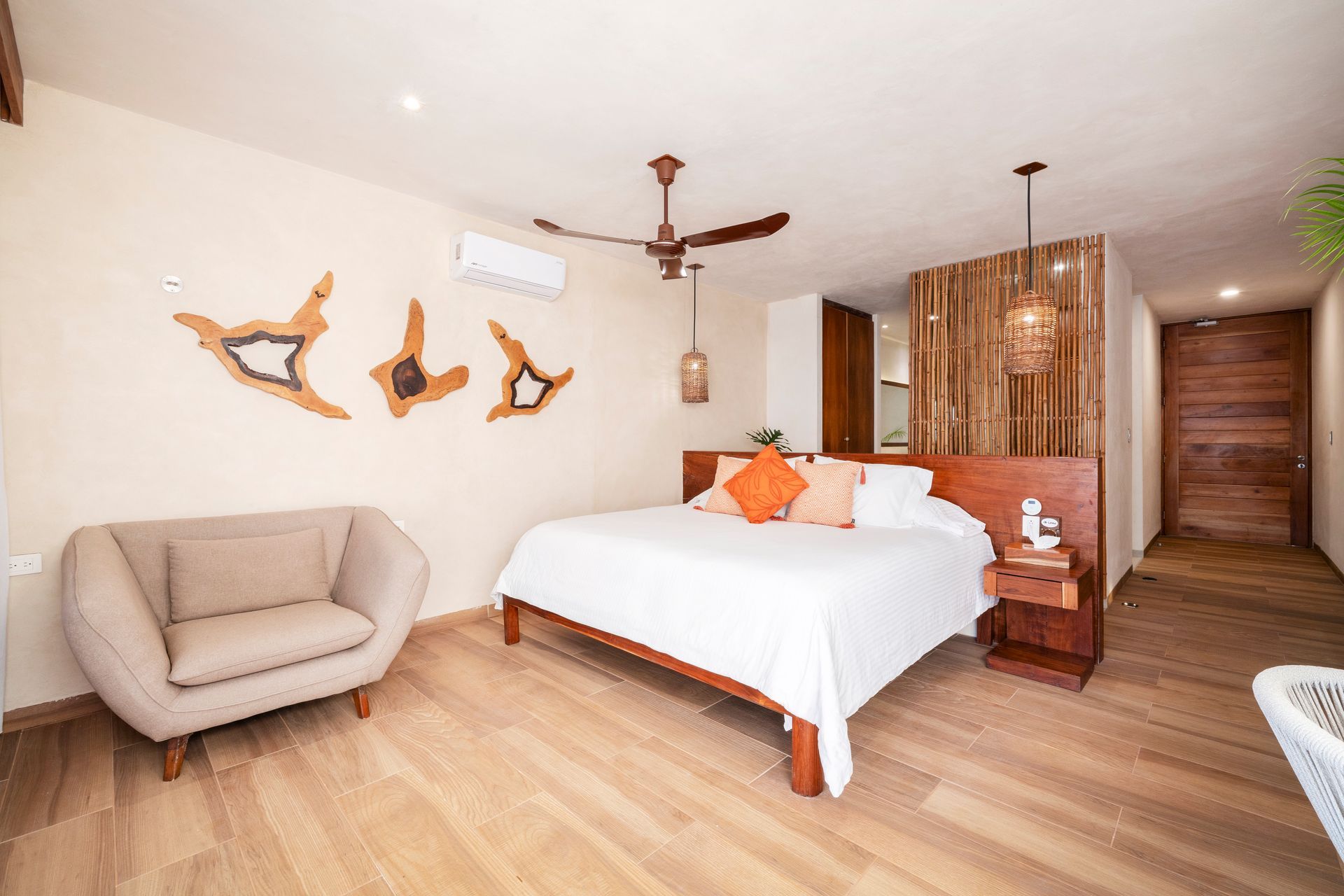 Bedroom with wooden furniture, natural wall decor, and a sitting area.