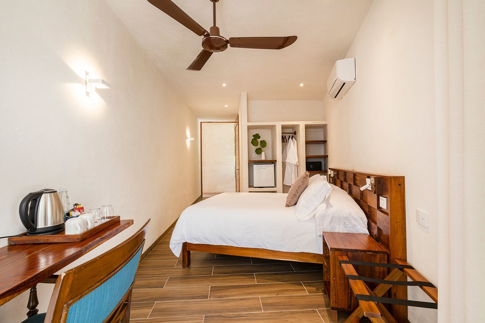 Bedroom with bed, desk, ceiling fan, and open closet. Bright room with wood accents.