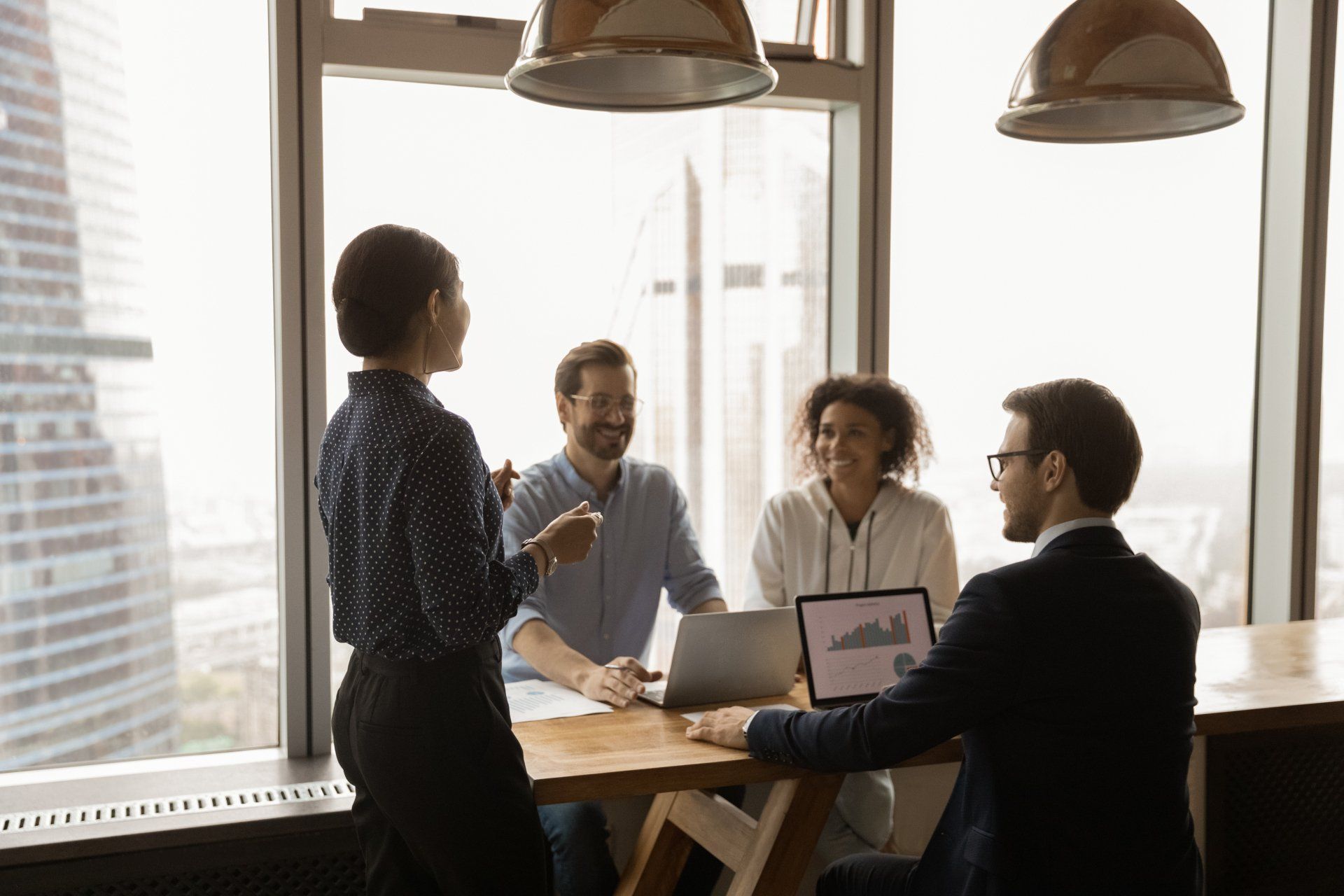 Indian businesswoman mentor leading corporate meeting in modern office with panoramic windows, boardroom, smiling colleagues sharing ideas, business partners discussing project strategy, negotiating