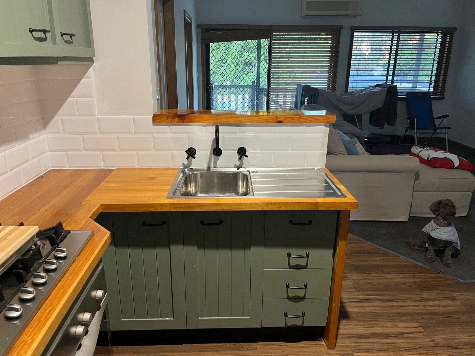 Plumber Repairing Tap In A Kitchen — Distinct Plumbing Services In Flinders NSW