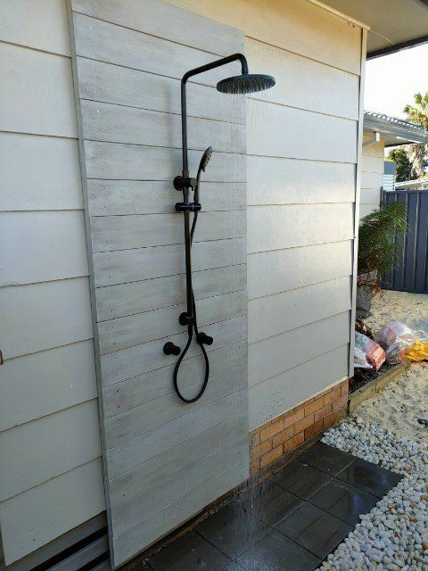 Plumber With Wrench Fixing The Pipe Under The Sink — Distinct Plumbing Services In Flinders NSW