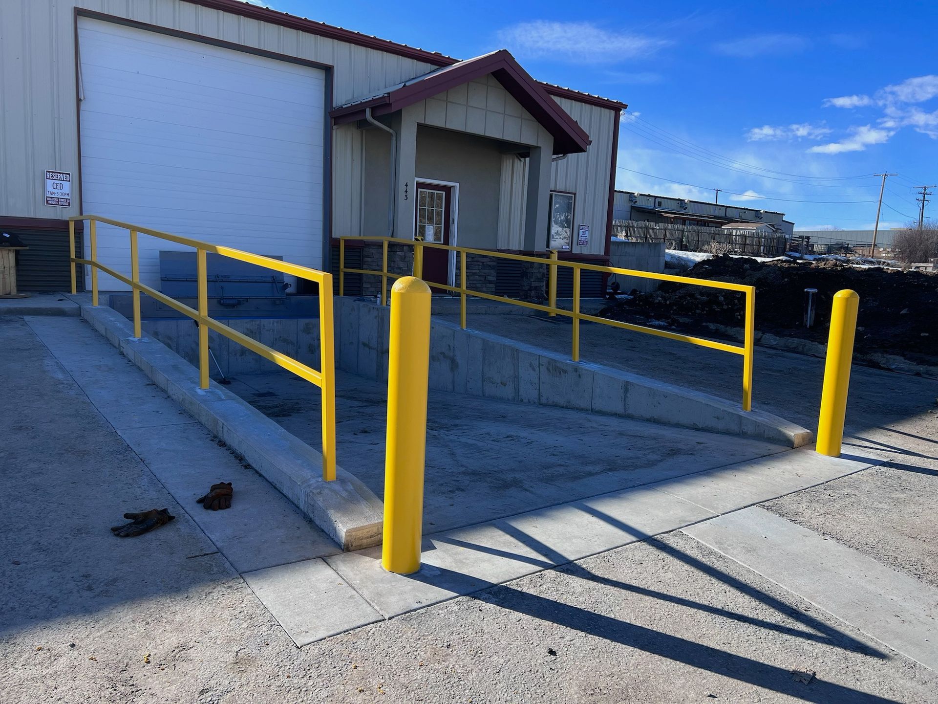 A ramp with a yellow railing leading to a building