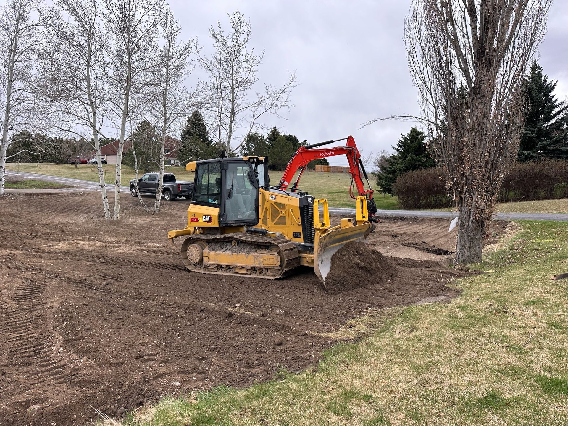 A bulldozer is driving through a dirt field.