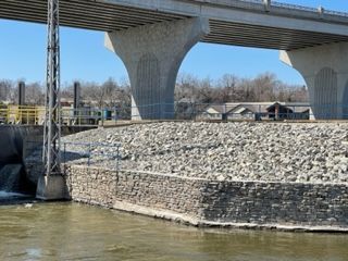 A bridge over a river with a stone wall in the foreground