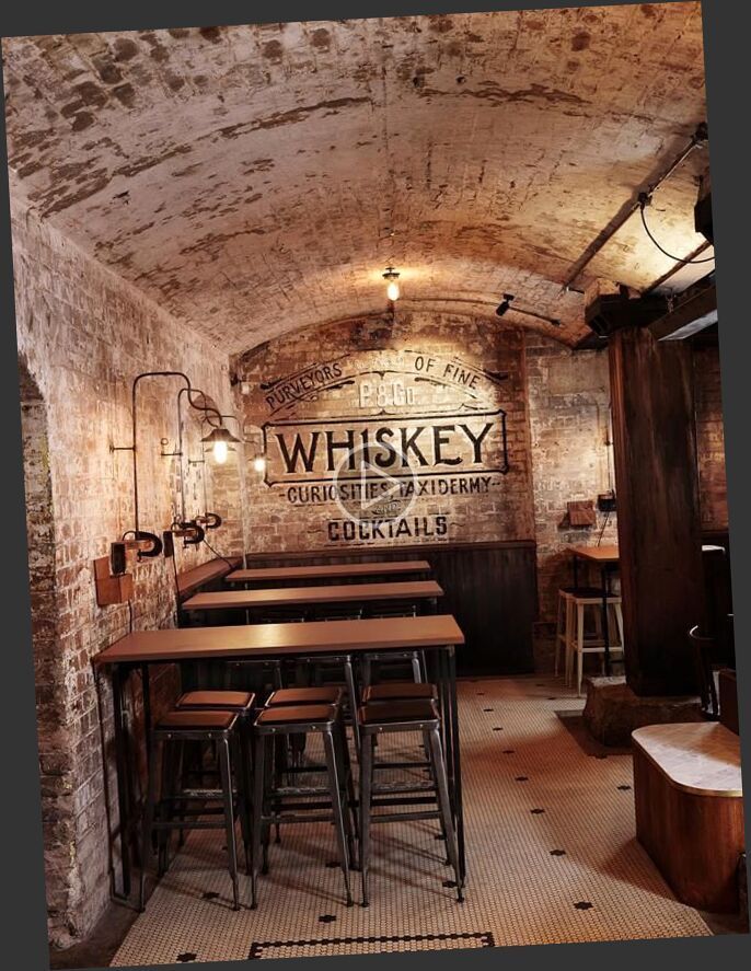 A brick wall with a sign that says whiskey cocktails