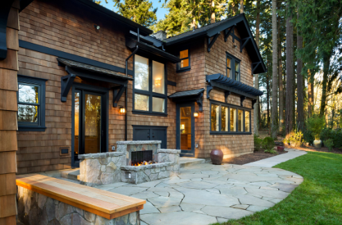 A large brick house with a fireplace in the backyard.