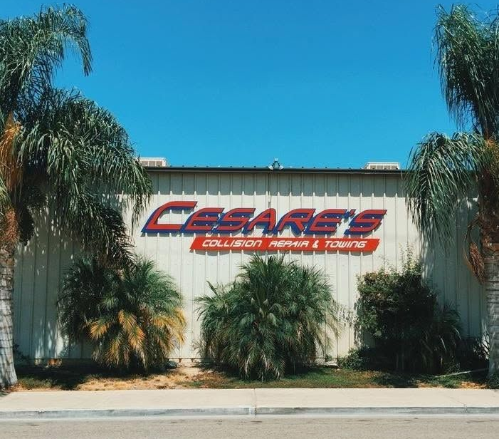 Cessna's building exterior with sign, surrounded by palm trees under a clear blue sky