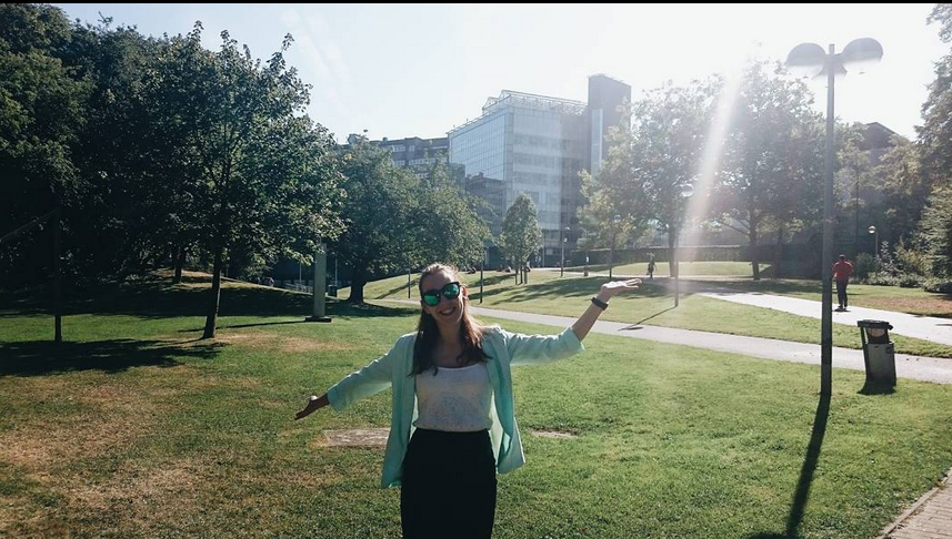 Vrouw staat blij voor de Vrije Universiteit van Brussel