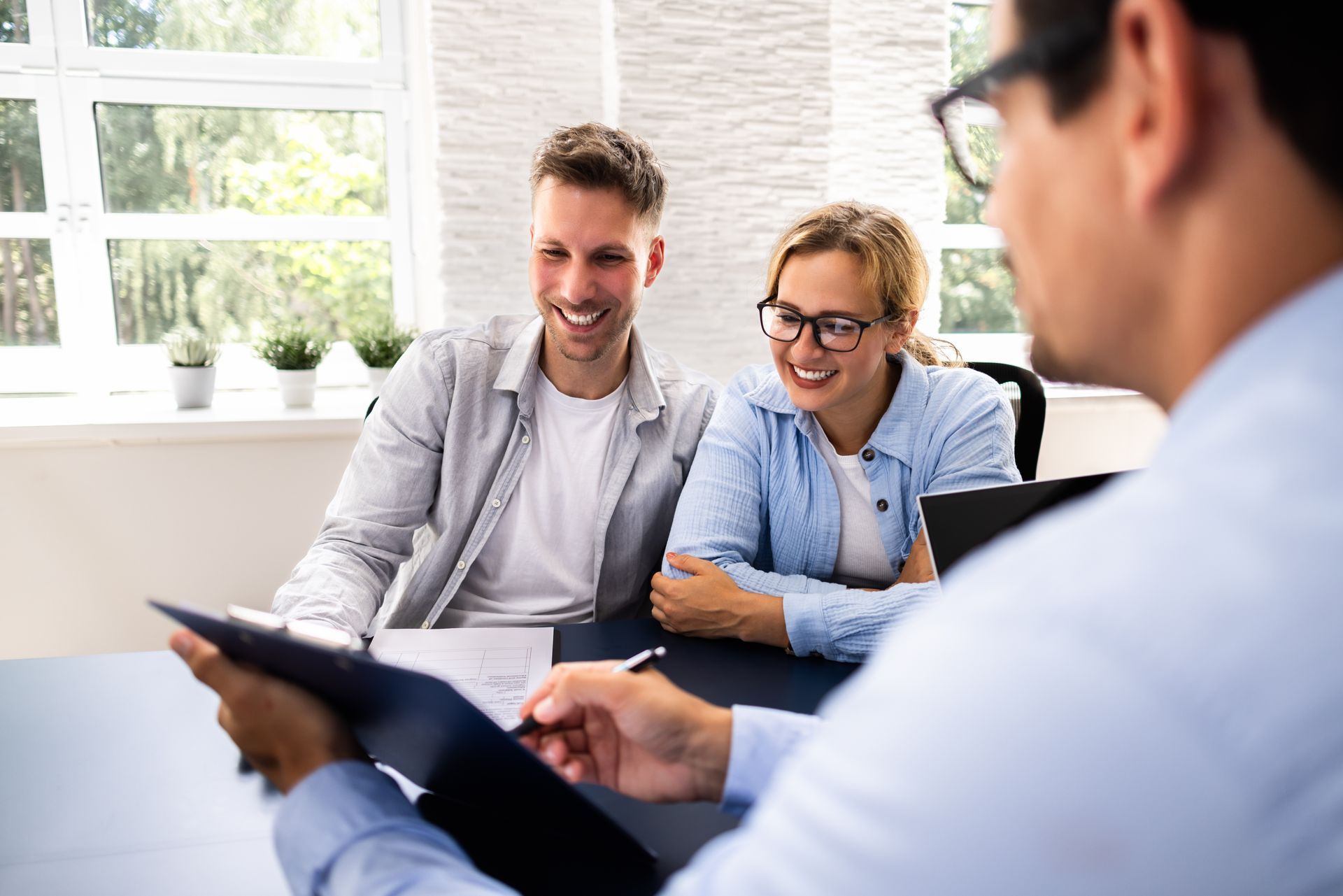 Personal insurance agency advisor reviewing home and auto coverage options with a family. Personal insurance agency advisor reviewing home and auto coverage options with a family.