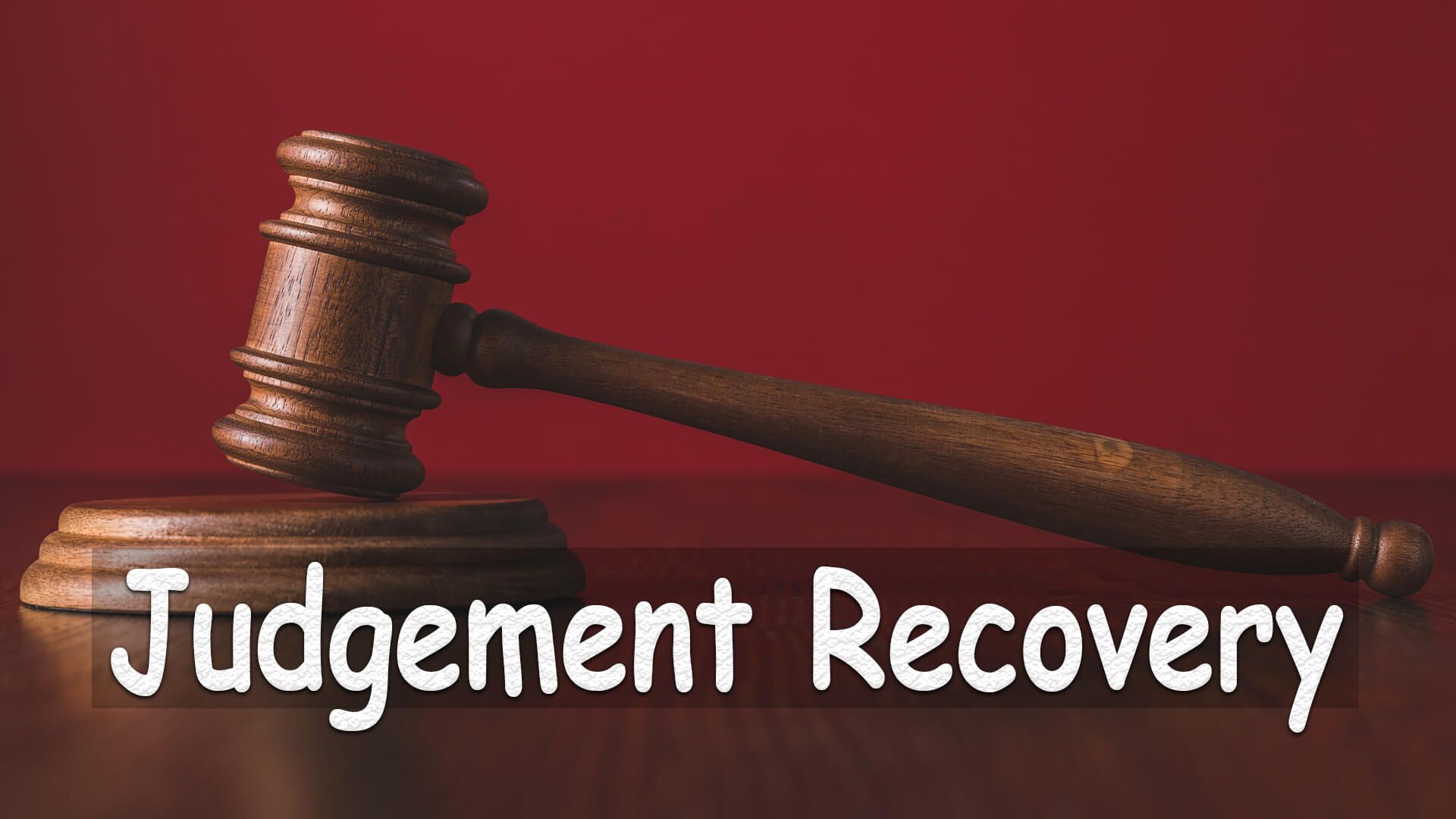 A judge 's gavel is sitting on a wooden table with the words judgement recovery written below it.