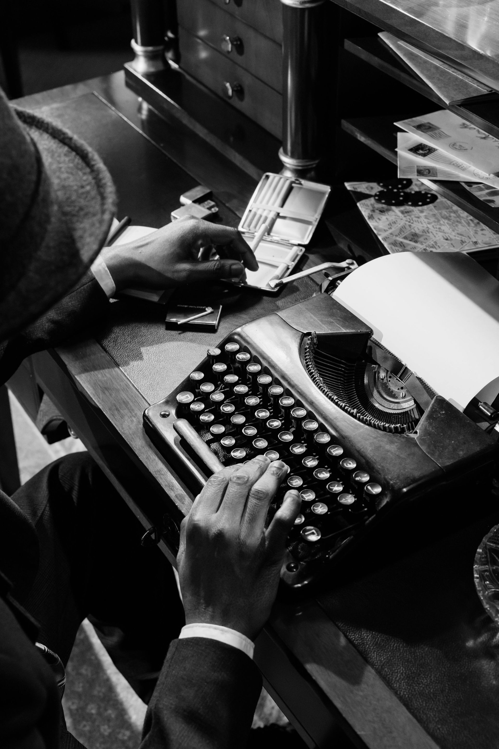 A man is typing on an old fashioned typewriter
