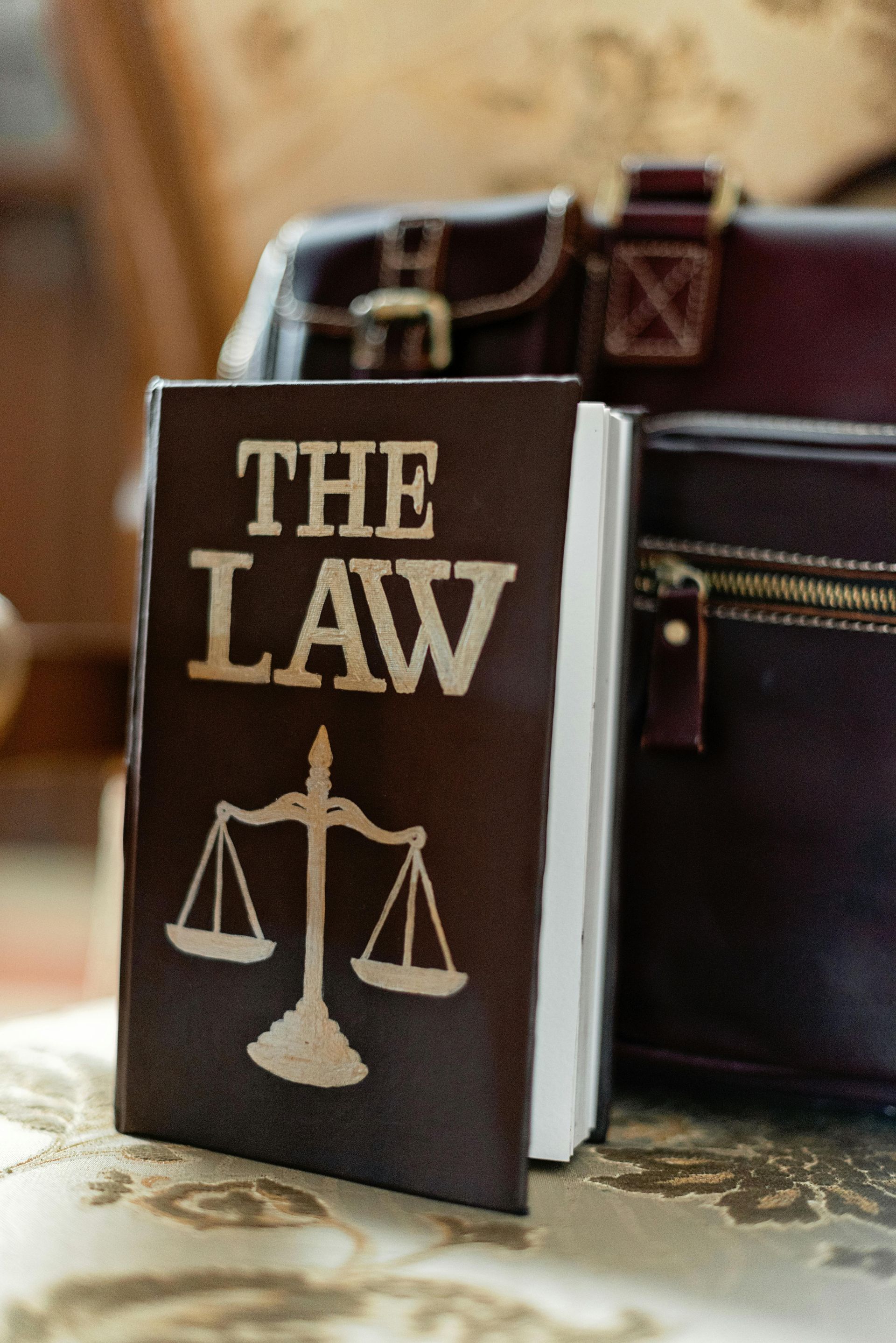 A book titled the law is sitting on a table next to a briefcase.