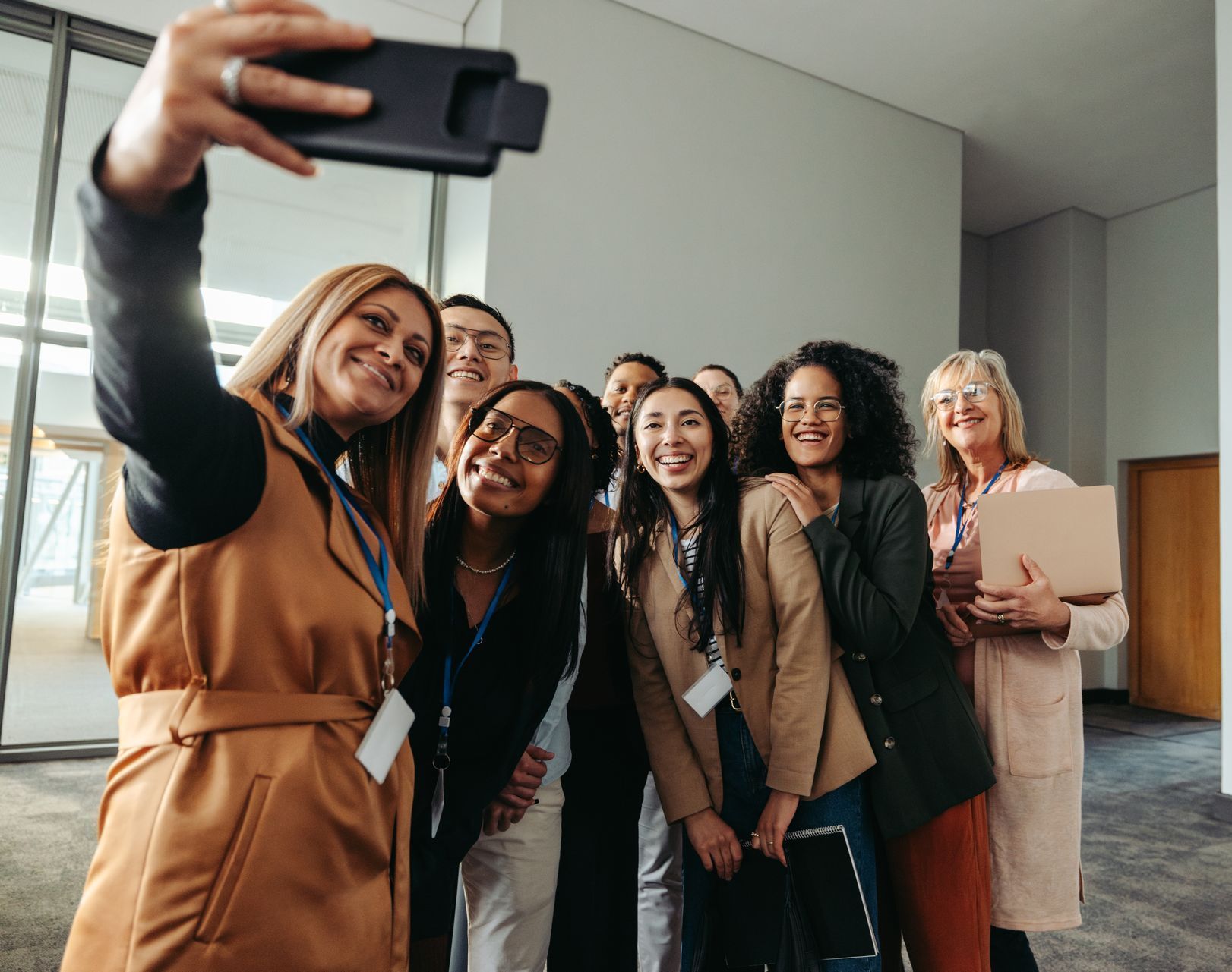 A woman is taking a selfie with a group of people.