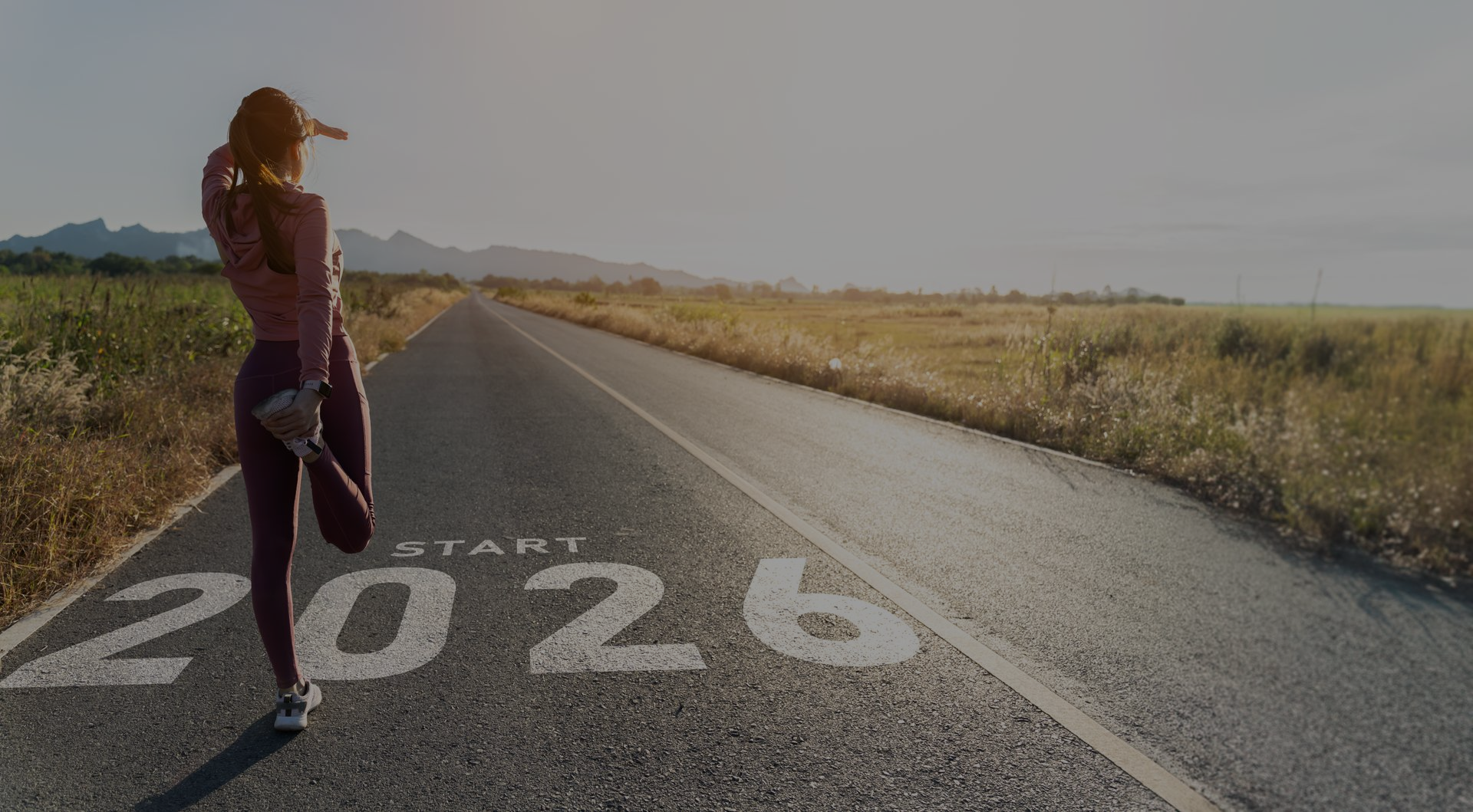 Woman stretches on road marked with 
