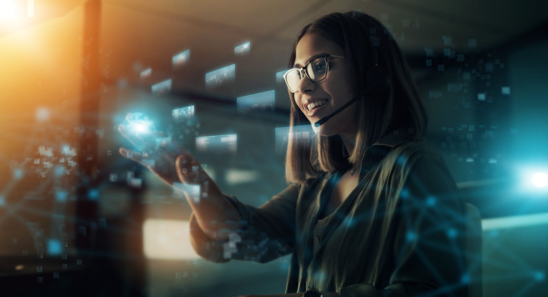 Person in glasses using a smartphone in a dim, futuristic workspace with blue digital graphics