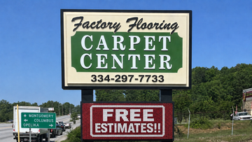 Carpet Center roadside sign with phone number and “Free Estimates,” under blue sky