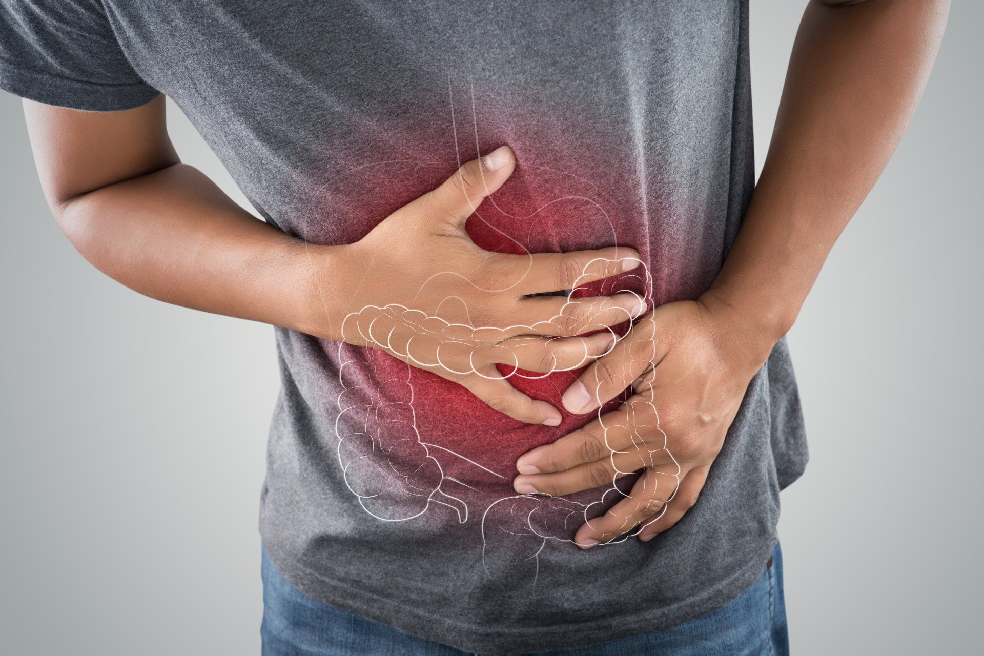The torso of a person holding their side as if in pain and a red haze radiating from the same area. A superimposed drawing of the stomach and large instestine.
