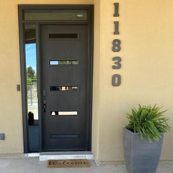 Black front door with house number 11830 and a potted green plant beside it.