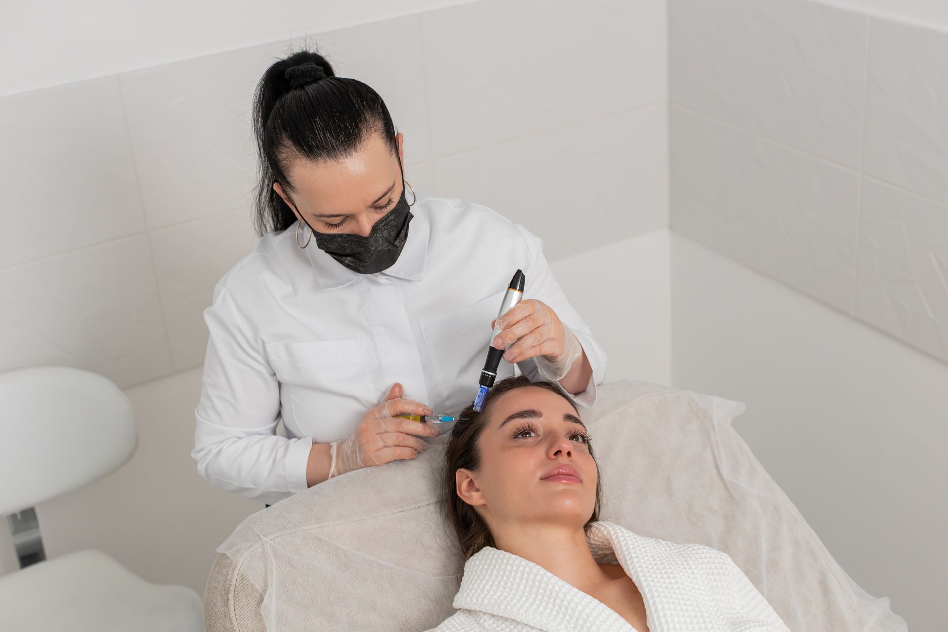Aesthetic clinician performing a facial treatment on a reclined patient in a clean spa room