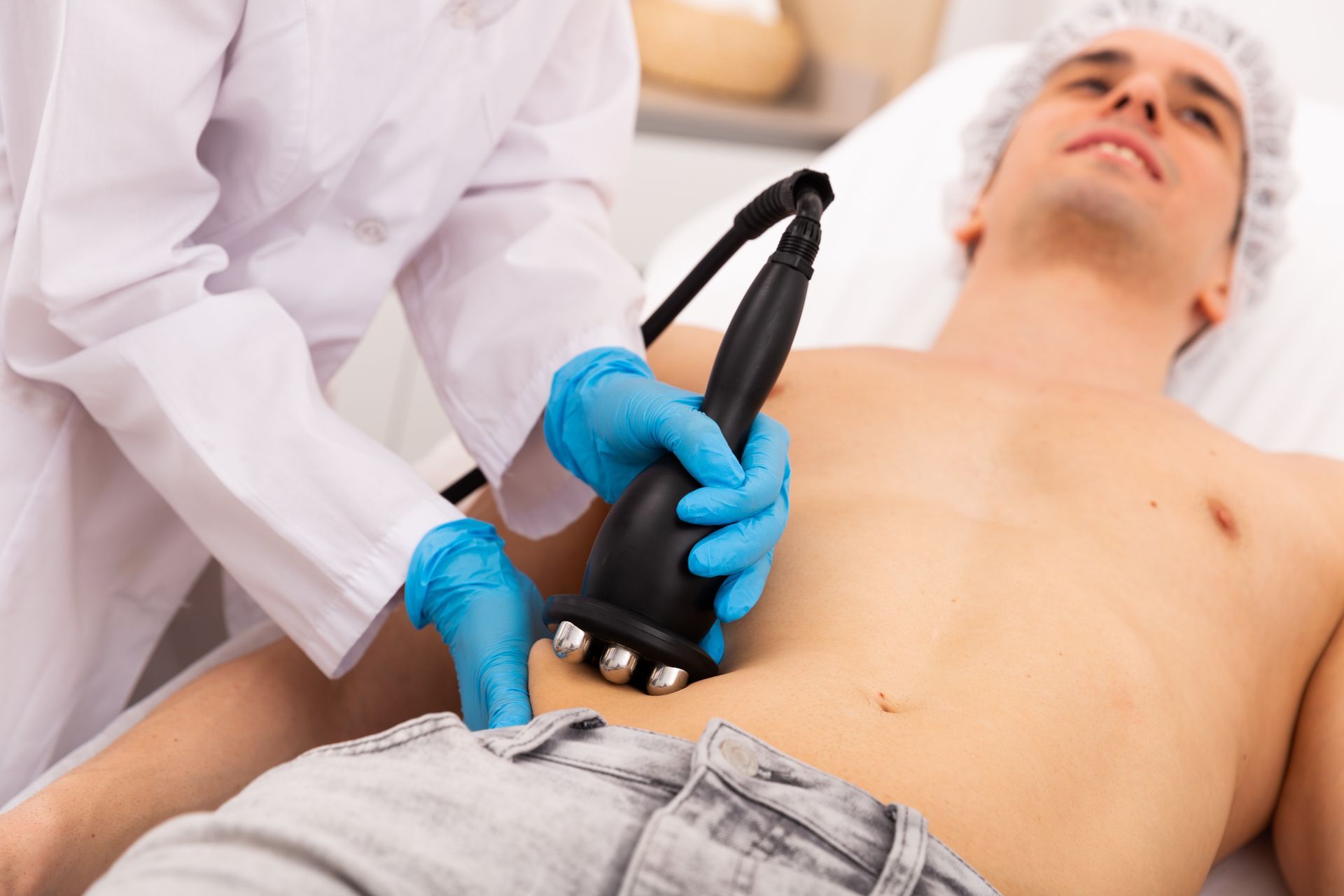 Medical professional performing an ultrasound scan on a patient's abdomen in a clinical setting Medical professional performing an ultrasound scan on a patient's abdomen in a clinical setting