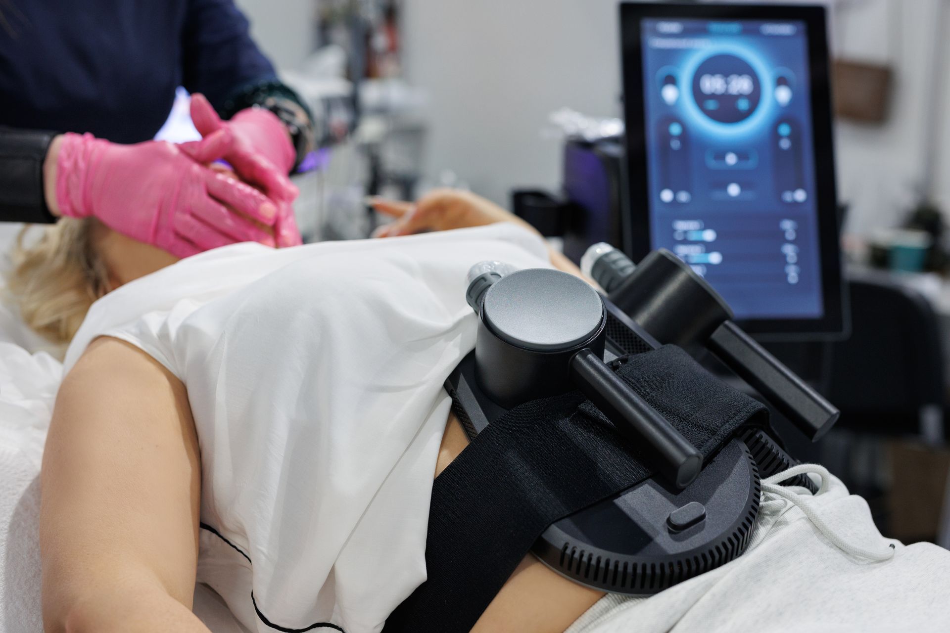 Person receiving a back treatment with a strapped device and control monitor in a clinic Person receiving a back treatment with a strapped device and control monitor in a clinic