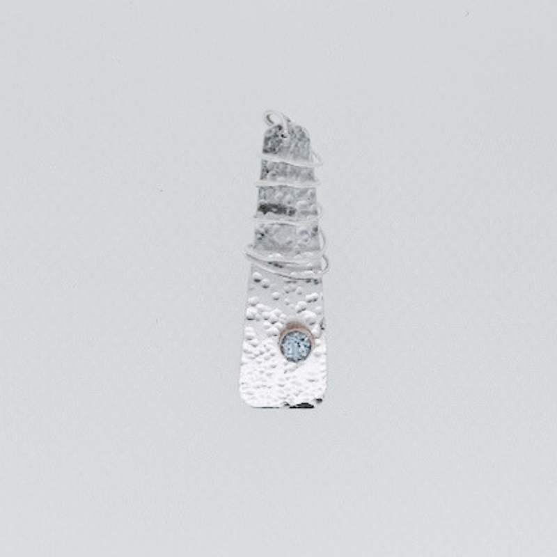 A silver ring with a blue stone in the middle on a white surface.