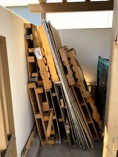 A pile of wooden pallets stacked on top of each other in a room.