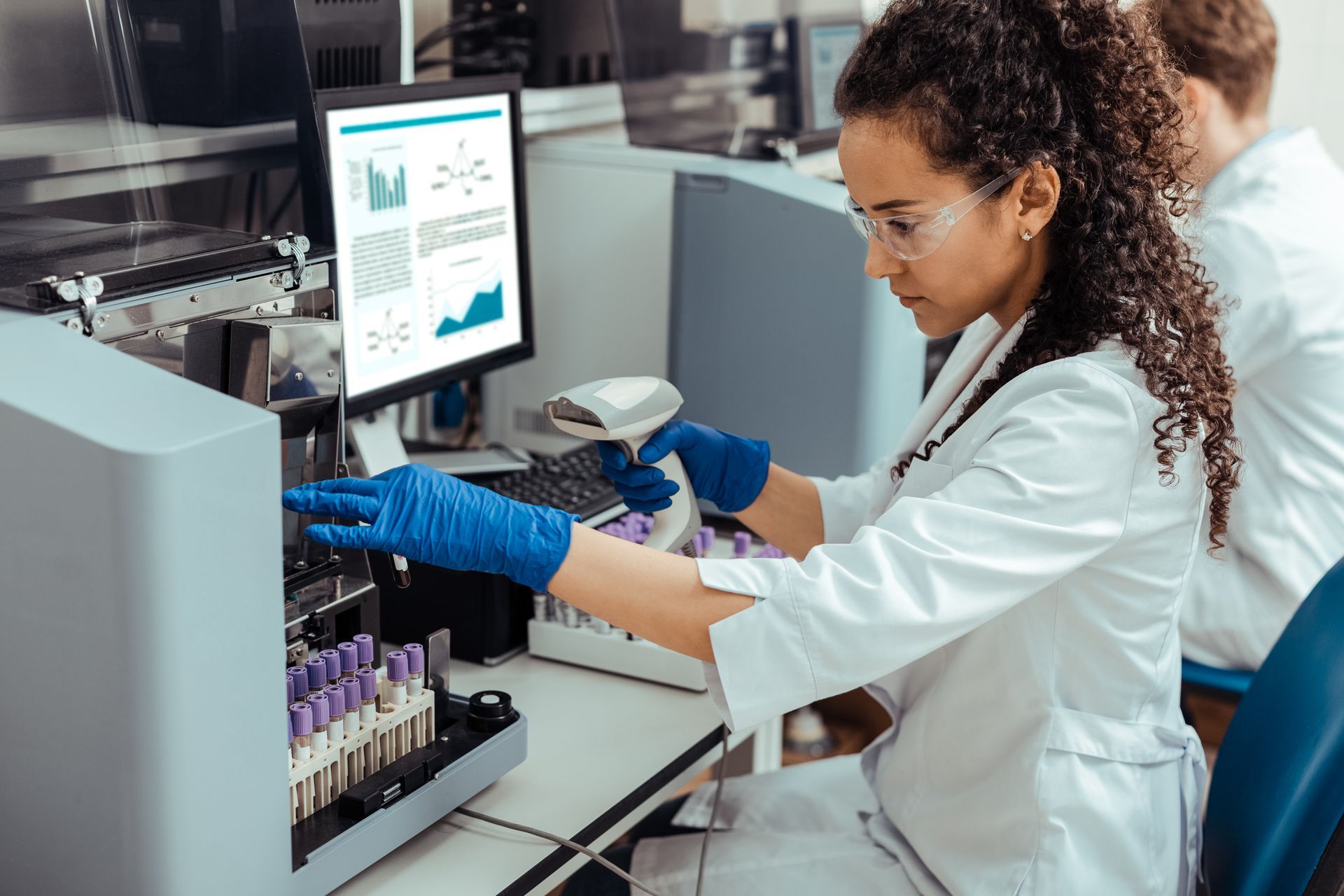 A woman in a lab coat is working on a machine.
