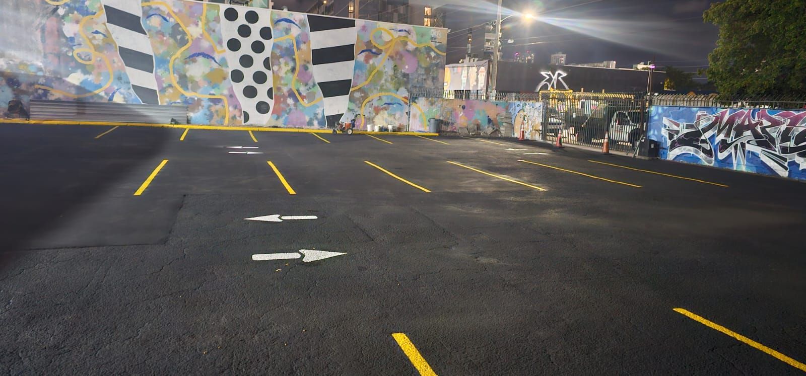 An empty parking lot with yellow lines, waiting for vehicles to fill the spaces.