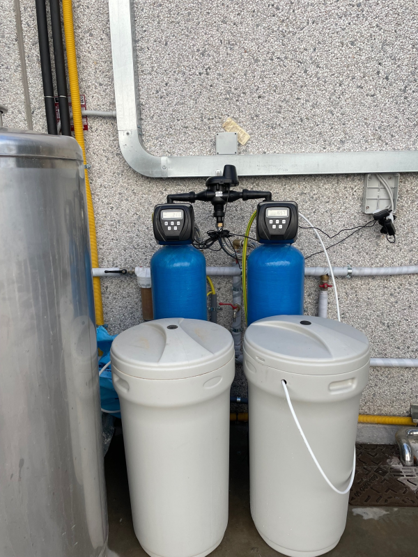 Sistema di filtraggio dell'acqua con due serbatoi blu, due serbatoi bianchi e pannelli di controllo digitali 