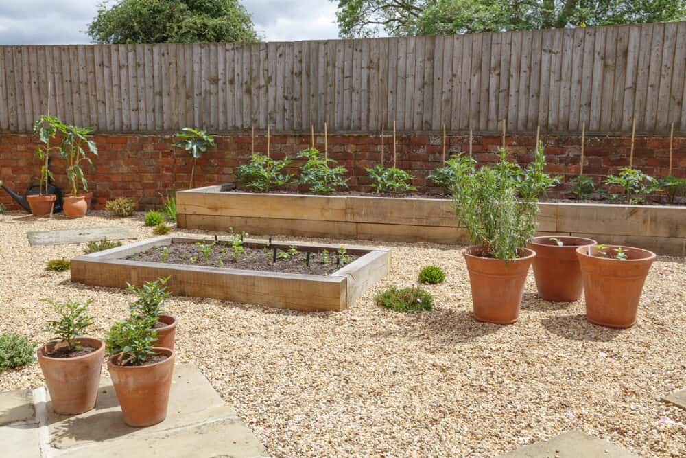 A garden with lots of potted plants and a wooden fence — Ourimbah Landscape Supplies In Ourimbah, NSW