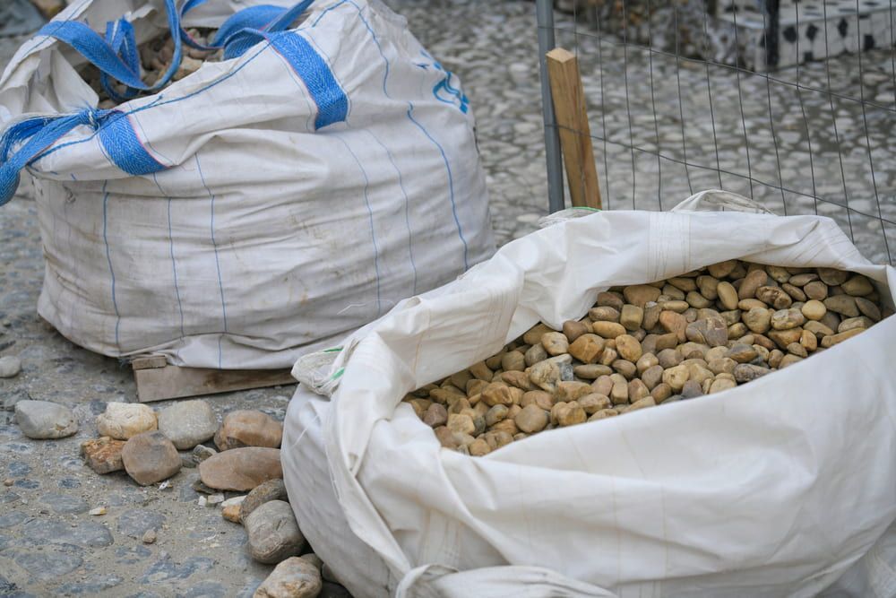 Two Large White Bags With Blue Handles — Ourimbah Landscape Supplies In Ourimbah, NSW