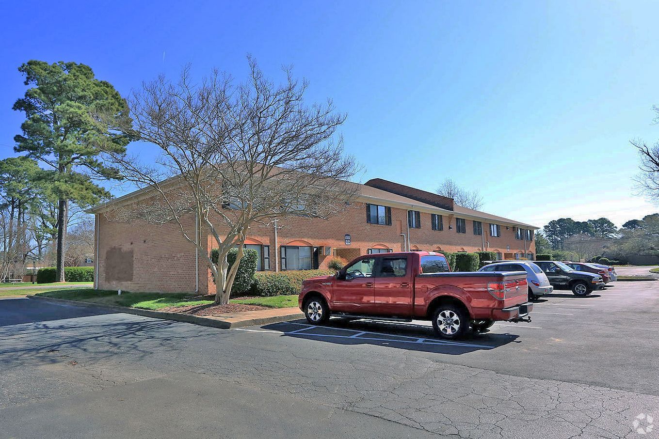 A red truck is parked in front of a building.