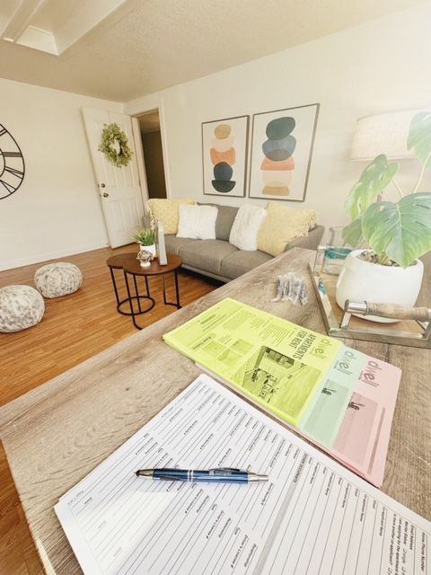 A living room with a couch and a clock on the wall