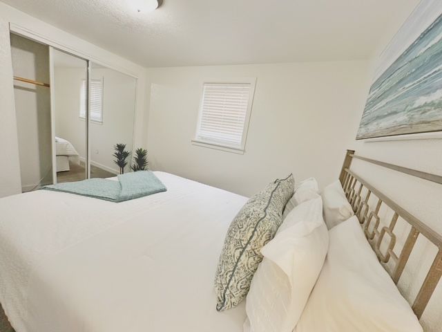 A bedroom with a king size bed and a painting on the wall.