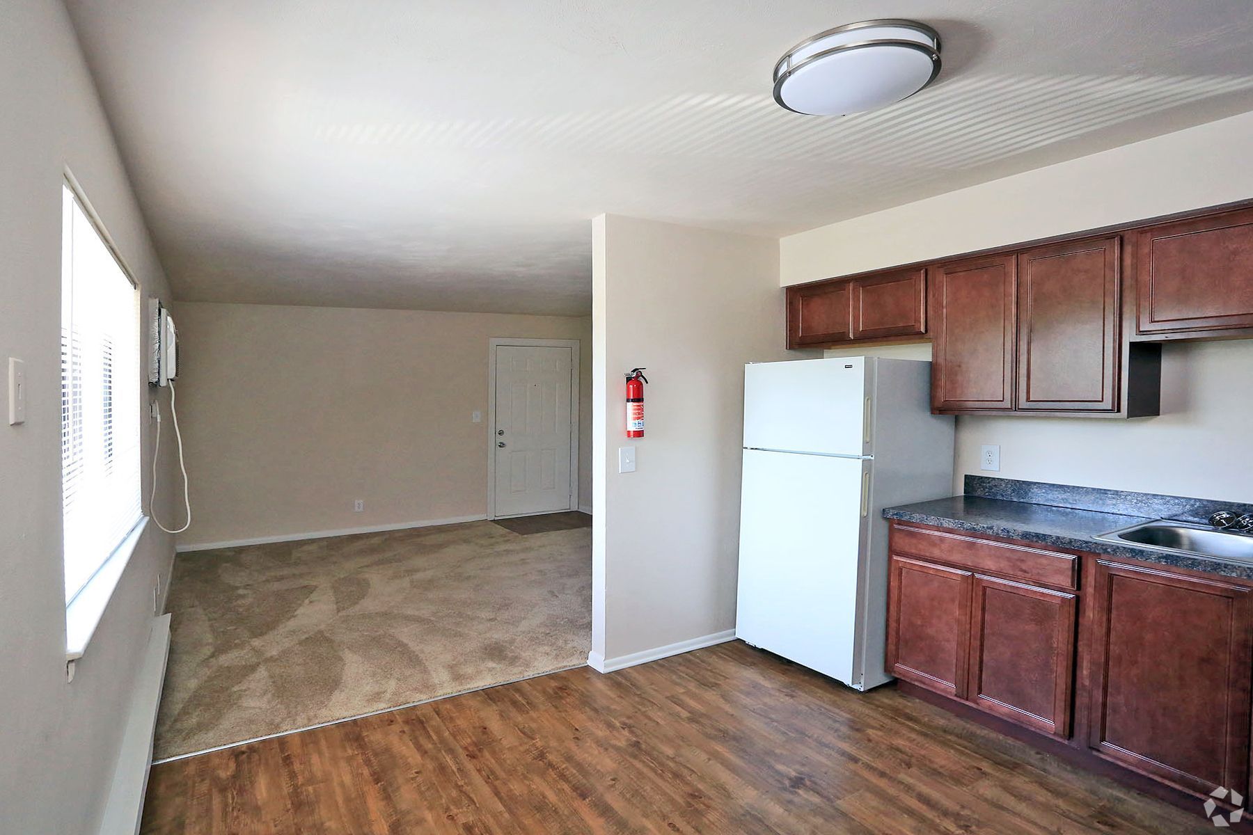 A kitchen with wooden cabinets and a white refrigerator