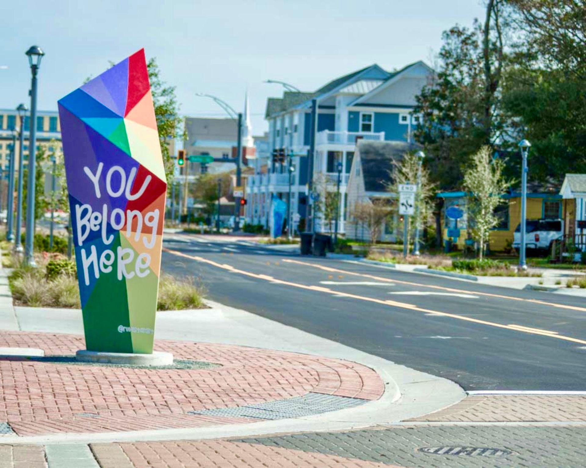 A sign on the side of a street that says you belong here