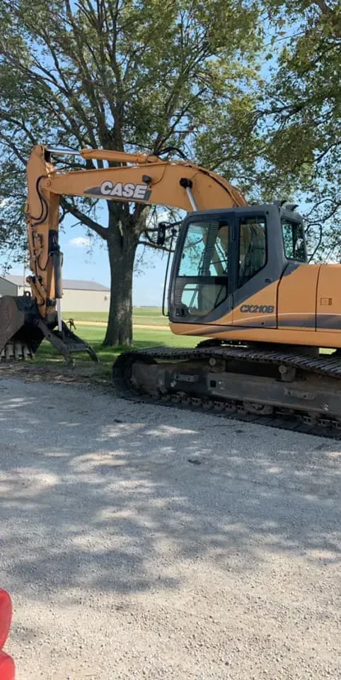 Orange CASE excavator on gravel in a sunny outdoor work site