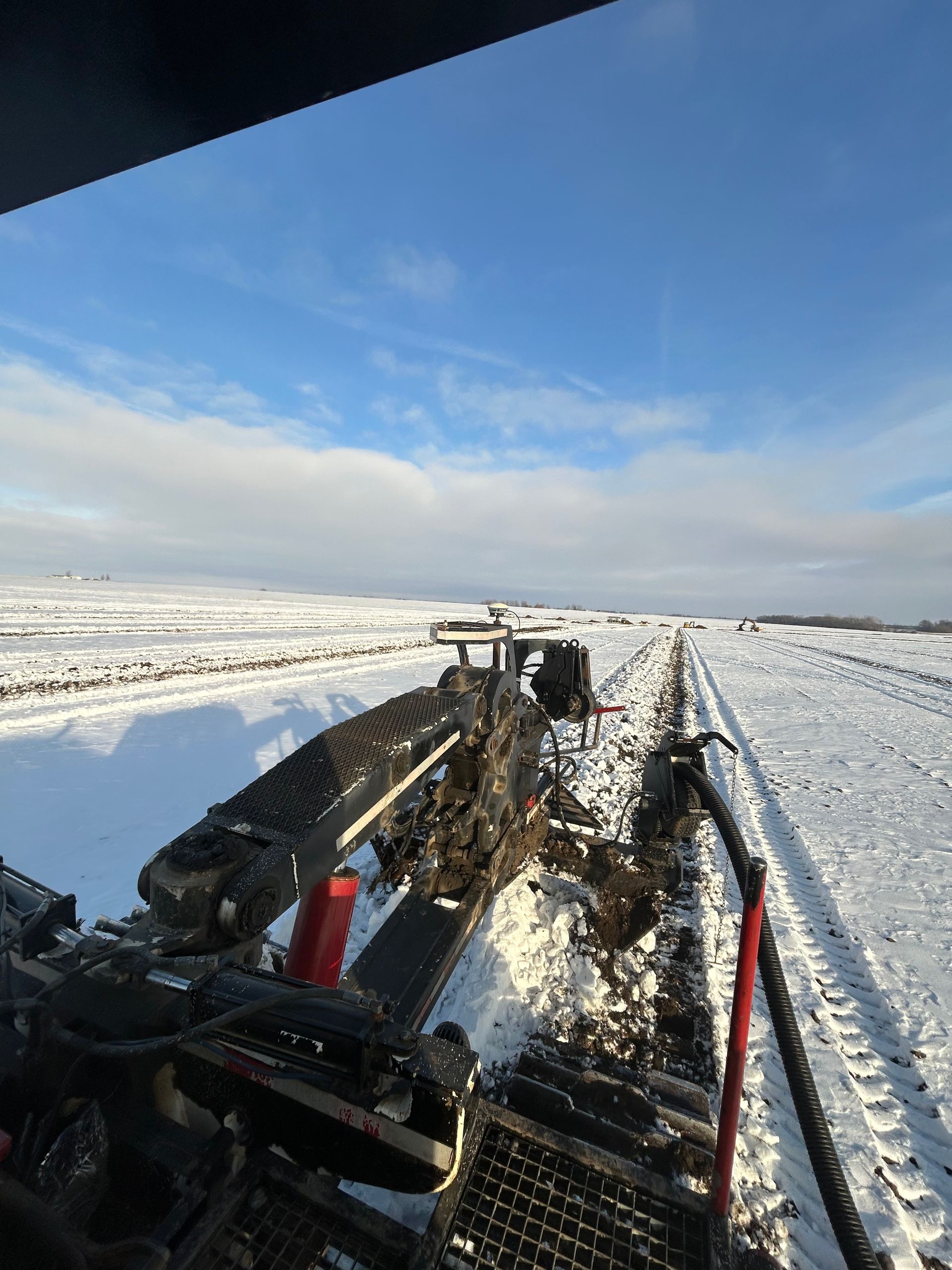 Oil rig machinery in a snowy, open landscape under a blue sky